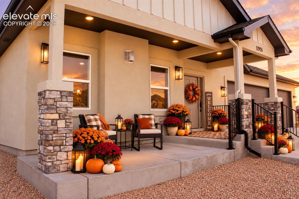 Image 3 of 44: Stucco exterior featuring stone column accents, a covered front porch, and 