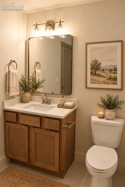 Image 35 of 44: Vanity with wood-finish cabinetry, white countertop, and integrated sink