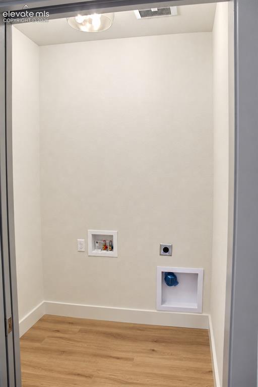 Image 37 of 44: Dedicated utility space featuring wood-finish flooring, white baseboards, a