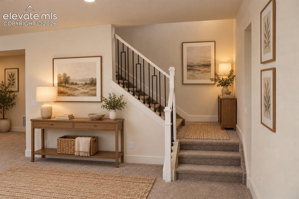 Image 38 of 44: Carpeted staircase with white newel posts and black metal balusters