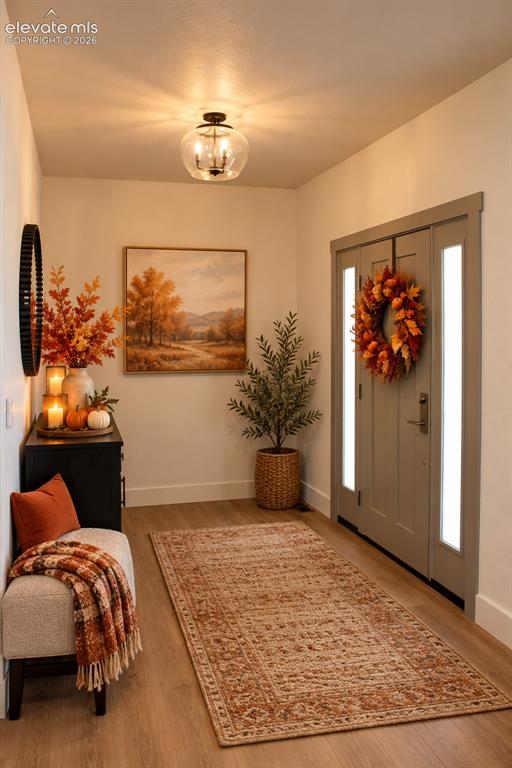 Image 7 of 44: Wood-finish flooring, recessed lighting, and a front entry door with vertic