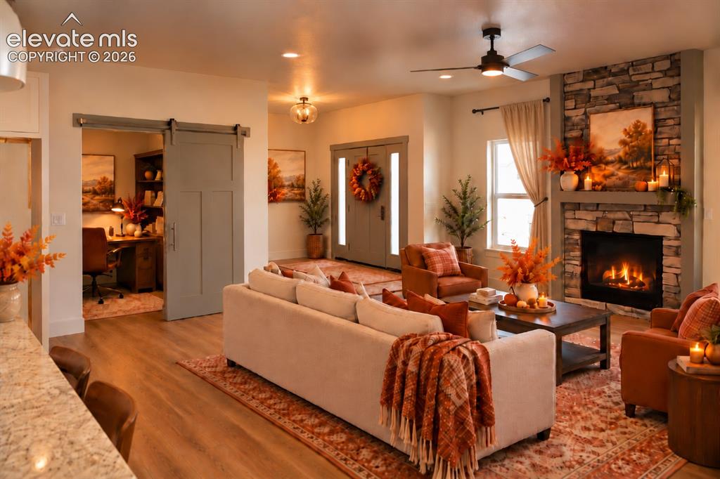 Image 9 of 44: Stone-clad fireplace with mantel, wood-finish flooring, recessed lighting, 
