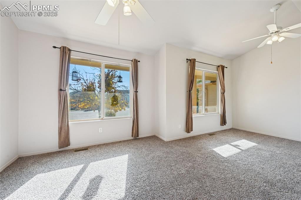 Image 14 of 37: Secondary bedroom on main main level - lots of light with two large windows