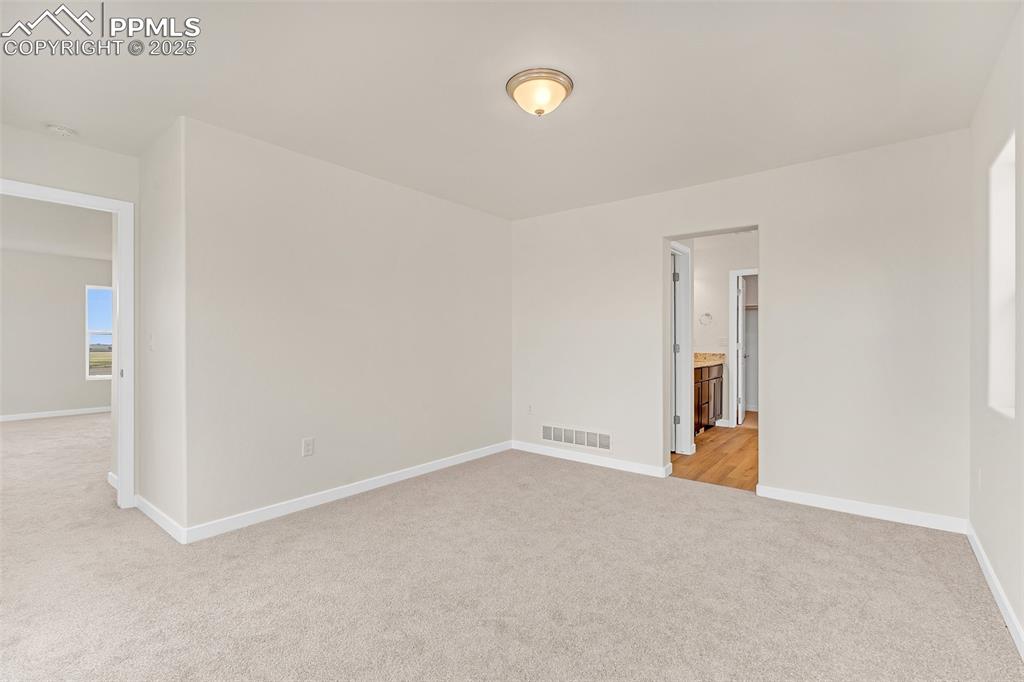 Image 23 of 29: Empty room with light carpet and a smoke detector