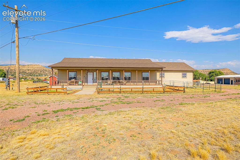 Image 1 of 38: Front of house with wheelchair ramp and fenced yard.