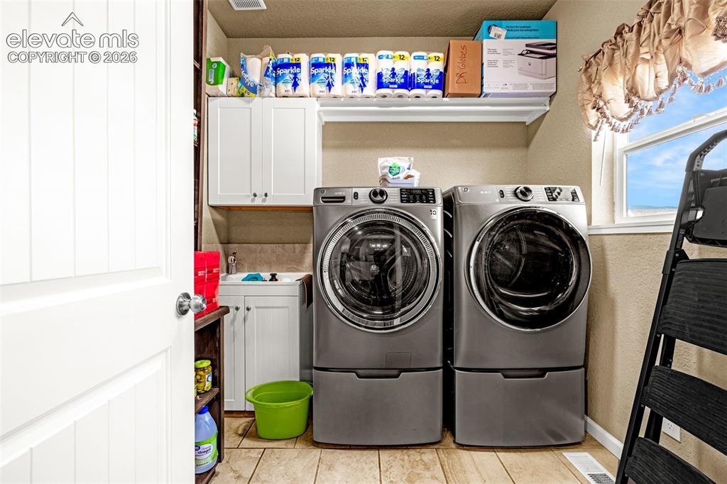 Image 13 of 38: Mud room with laundry and wash sink.