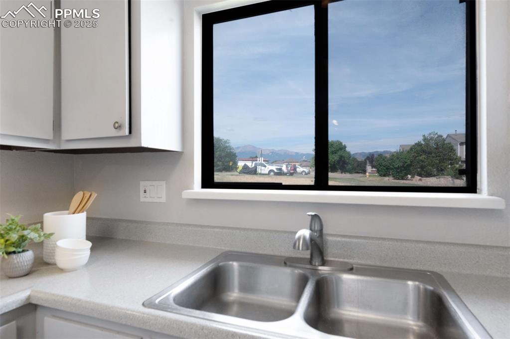 Image 11 of 26: Kitchen view of white cabinets and light countertops