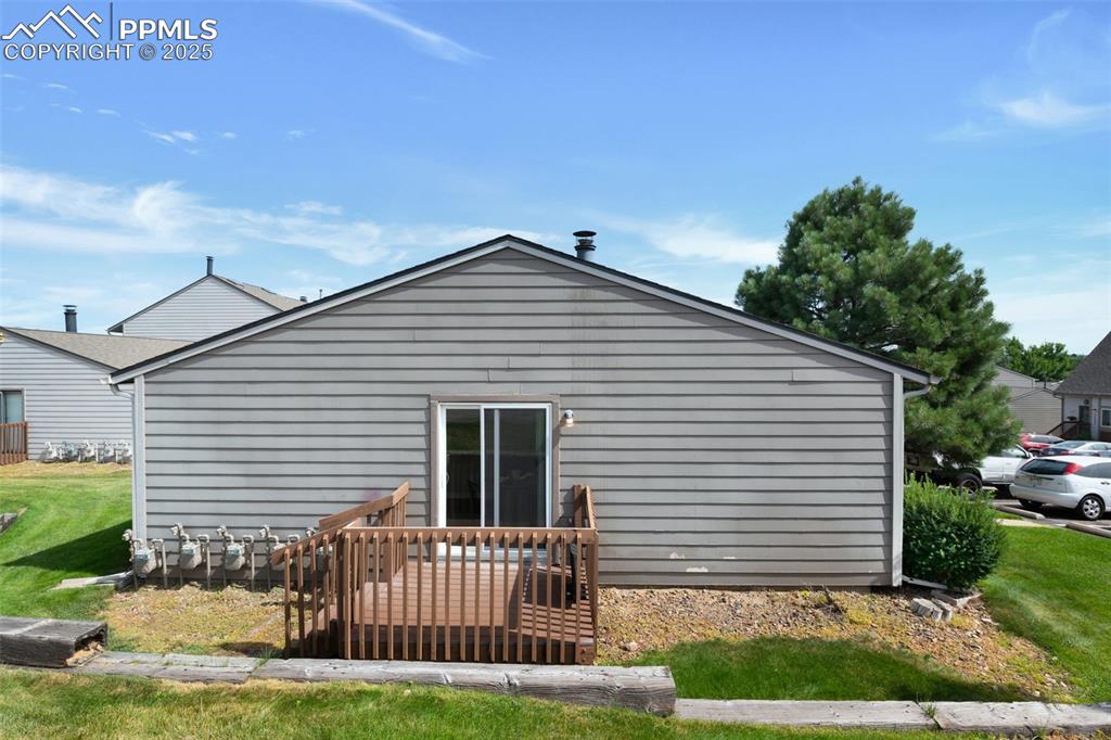 Image 23 of 26: Rear view of house featuring a lawn