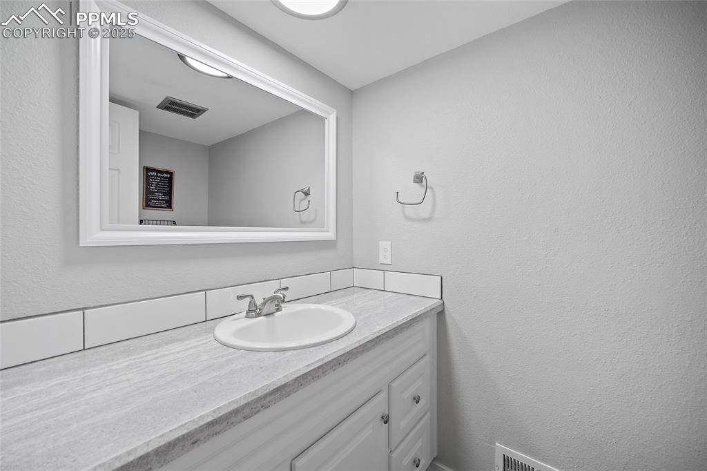 Image 15 of 34: Bathroom with a textured wall and vanity