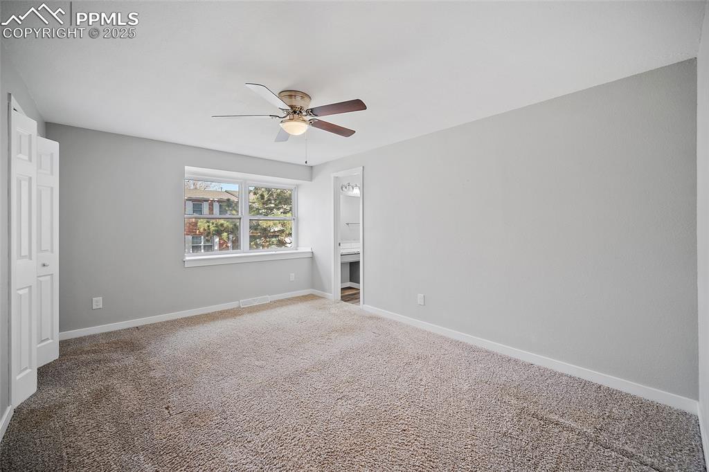 Image 20 of 34: Unfurnished bedroom featuring carpet, a ceiling fan, and ensuite bath