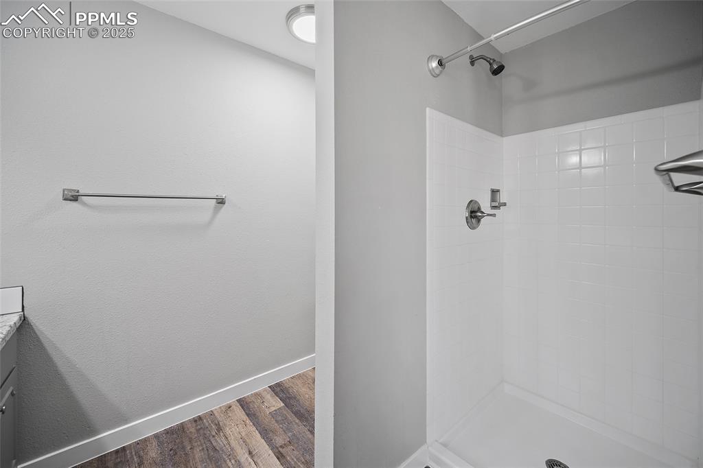 Image 23 of 34: Bathroom with dark wood-style floors, a stall shower, and vanity