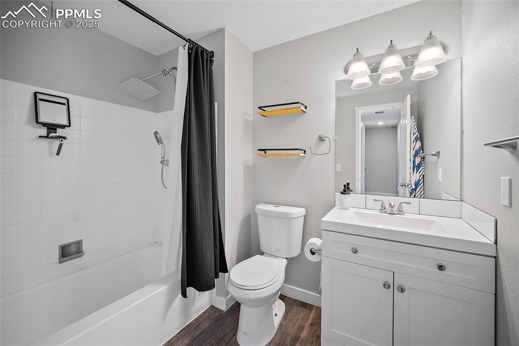 Image 24 of 34: Bathroom featuring shower / bath combo, dark wood-style floors, and vanity