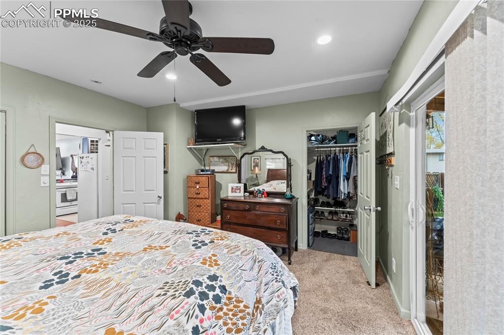 Image 16 of 27: Bedroom with light colored carpet, ceiling fan, a walk in closet, recessed