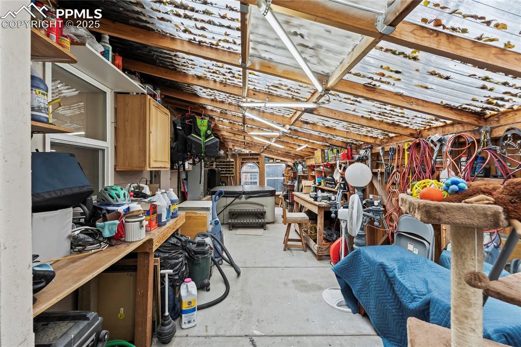 Image 17 of 27: Miscellaneous room with unfinished concrete flooring and vaulted ceiling