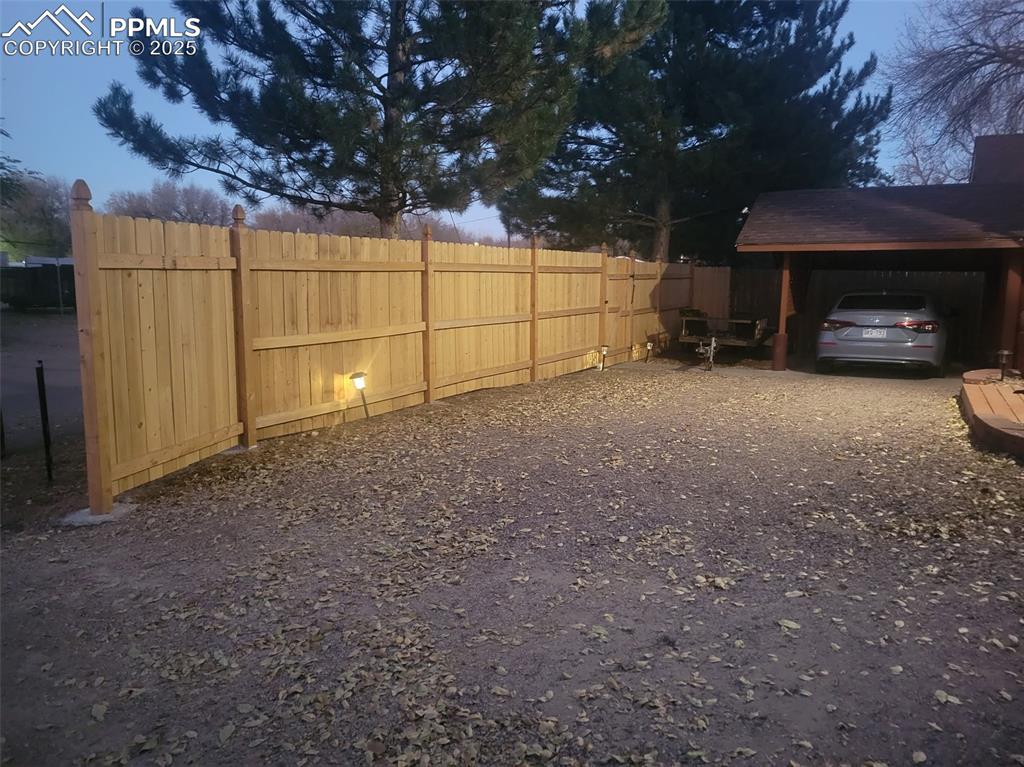 Image 23 of 27: View of yard featuring a carport and driveway