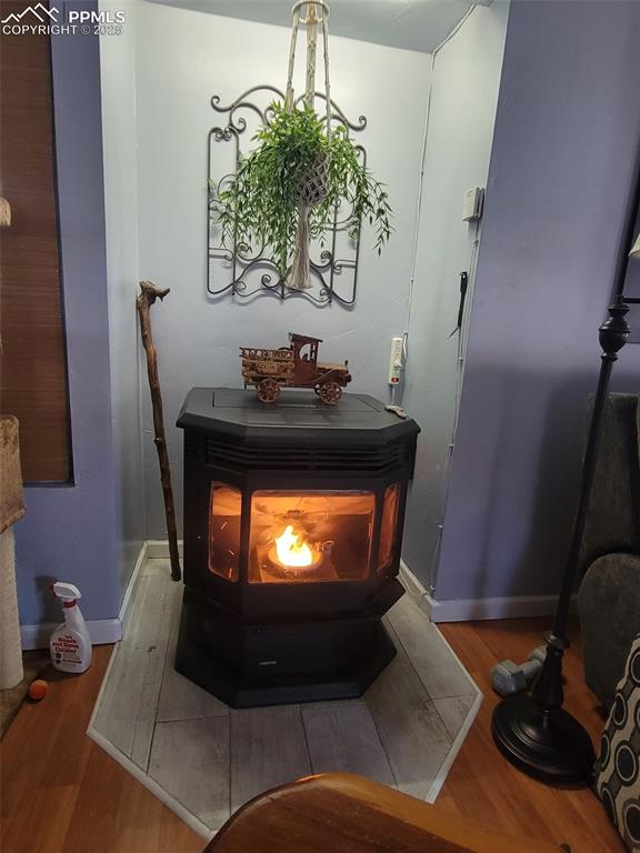 Image 6 of 27: Detailed view of wood finished floors and a wood stove