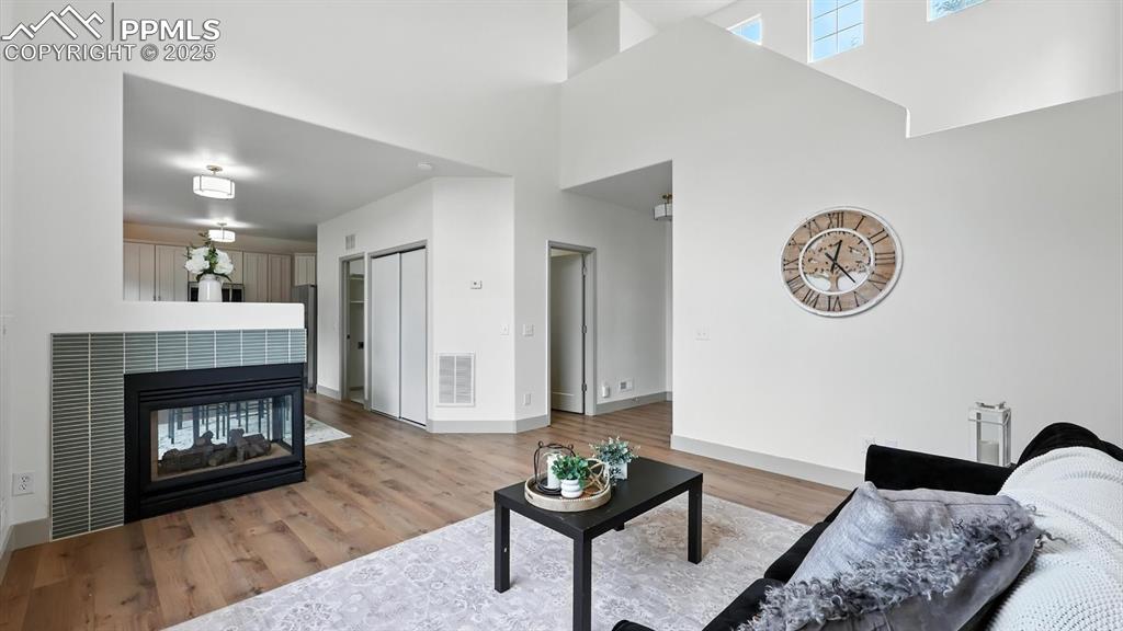 Image 10 of 50: Living Room with pier style gas fireplace shared with the dining area.