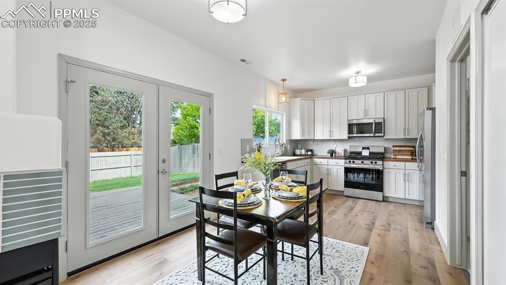 Image 11 of 50: The dining area is located off the kitchen and has French doors out to the