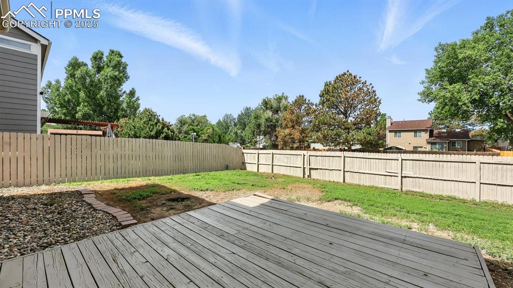 Image 13 of 50: The backyard deck is ideal for summer barbecues, sunset dinners, or simply
