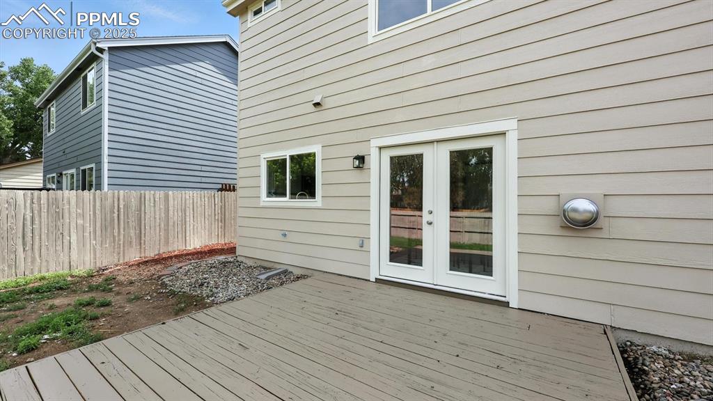 Image 14 of 50: Backyard deck with French door into the dining area.