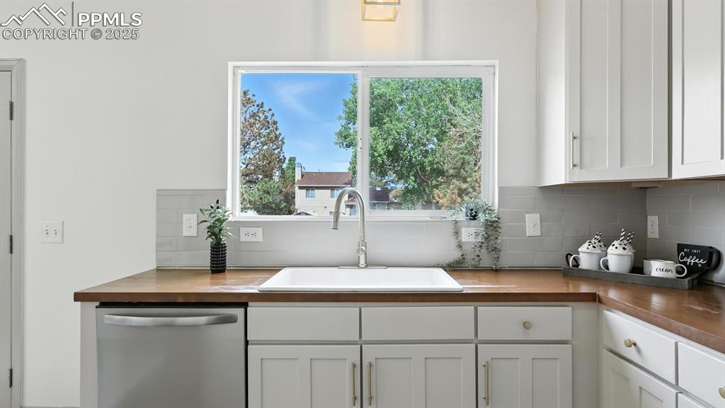 Image 16 of 50: The kitchen offers abundant white cabinetry and brand new butcher block cou