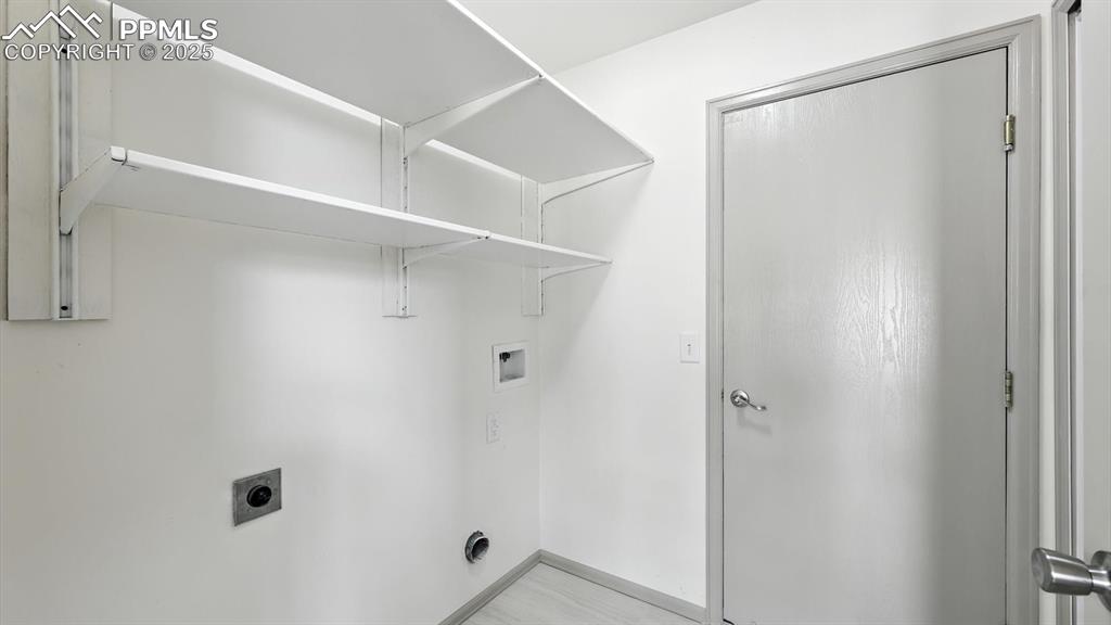 Image 18 of 50: The laundry room is located off the kitchen with built in shelves and garag
