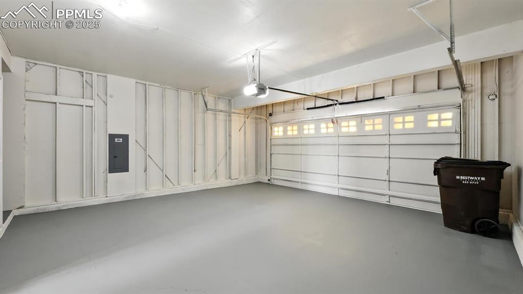 Image 19 of 50: Two-car attached garage with newly painted concrete floor and door opener.