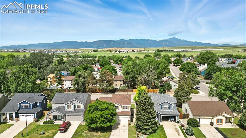 Image 2 of 50: Aerial view of the front of the house, neighborhood, and spectacular mounta
