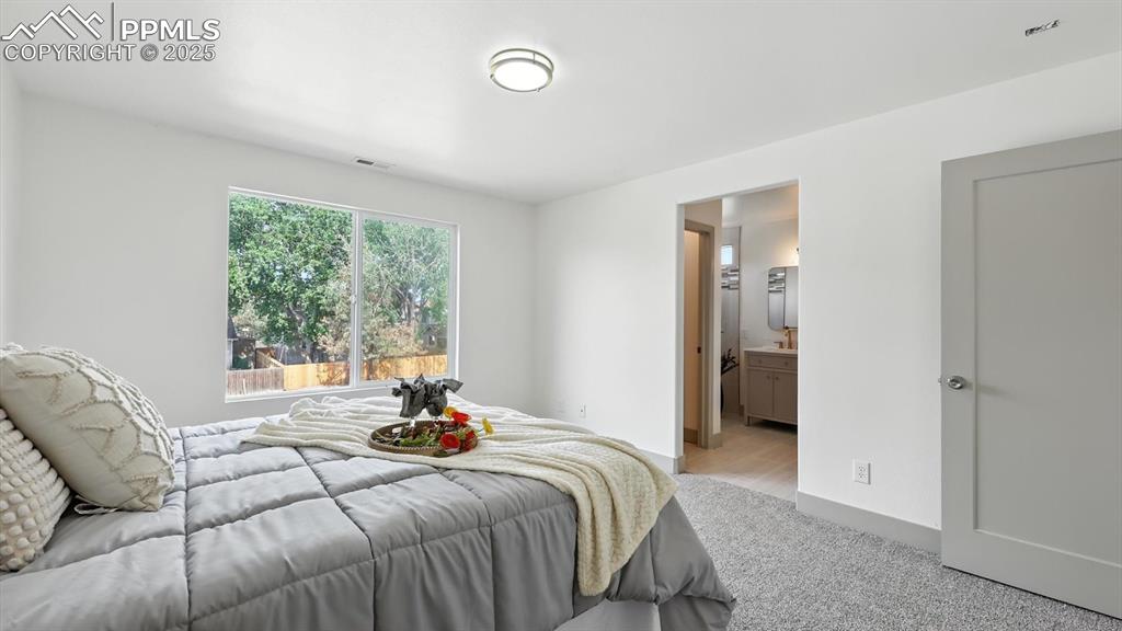 Image 34 of 50: The upper level primary suite offers an adjoining full bathroom with featur