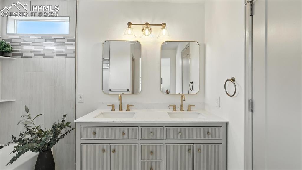 Image 35 of 50: Updated primary bathroom with a dual sink vanity and framed mirrors.