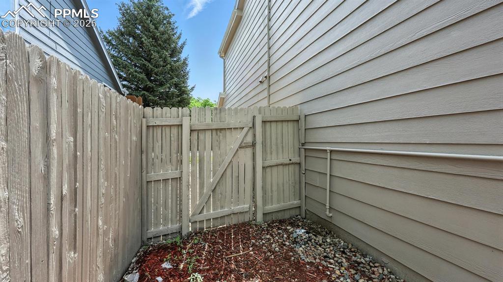 Image 42 of 50: Xeriscaped side yard with gate to the front yard.