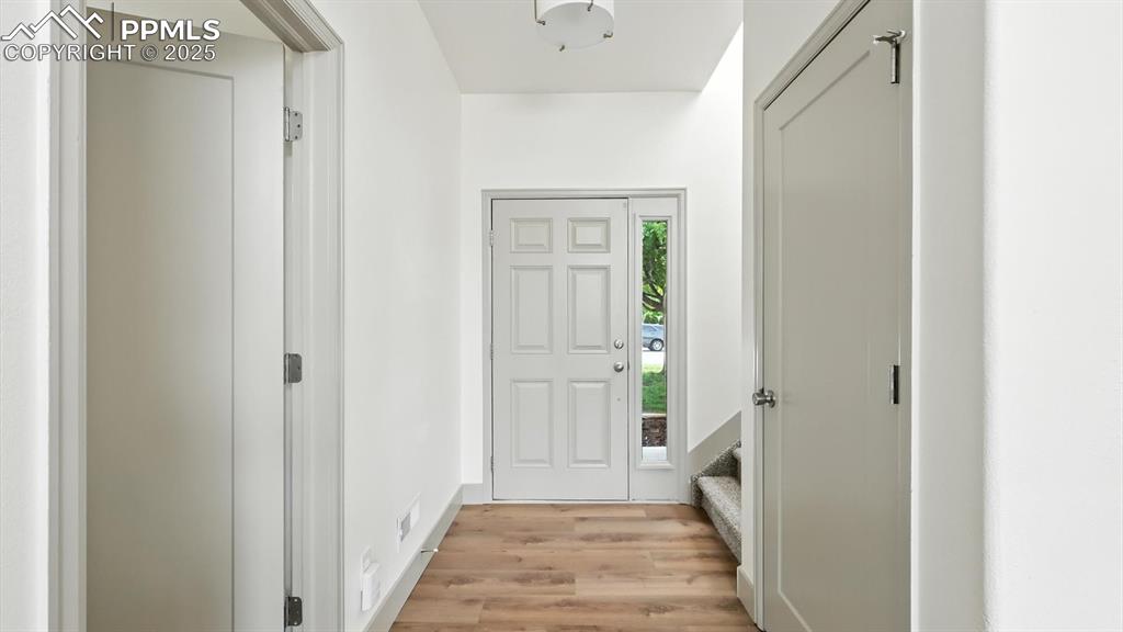 Image 6 of 50: Front entry with new rich wood laminate floors and stairs to the upper leve