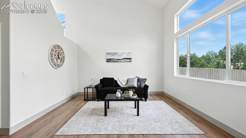 Image 8 of 50: The living room boasts soaring vaulted ceilings and a large view window fac