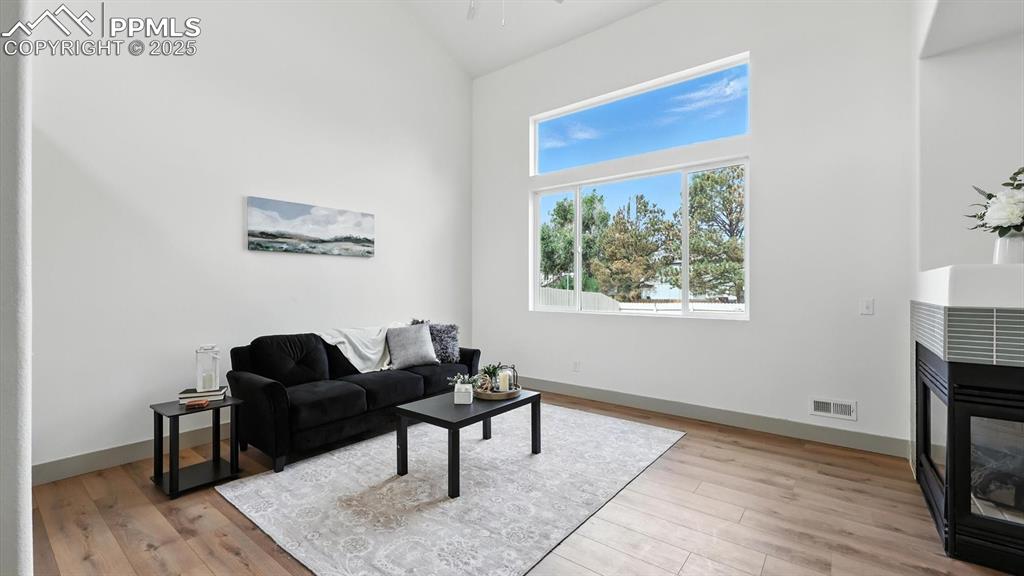 Image 9 of 50: The living room features a cozy pier style gas fireplace that invites quiet