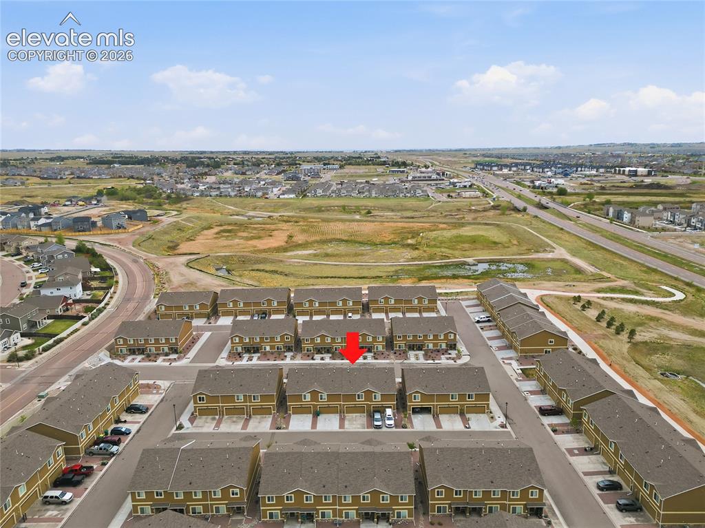 Image 47 of 48: Aerial perspective of a multi-unit residential development with uniform arc