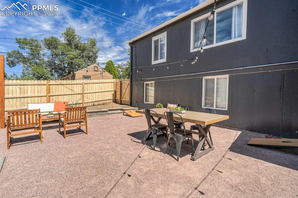 Image 2 of 24: View of patio featuring outdoor dining space and a fenced backyard