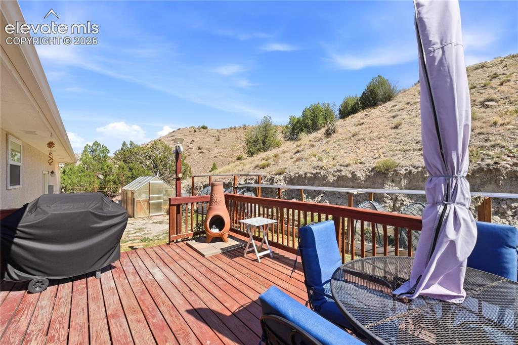 Image 10 of 49: Expansive redwood deck with cable railing overlooking hillside landscape, f