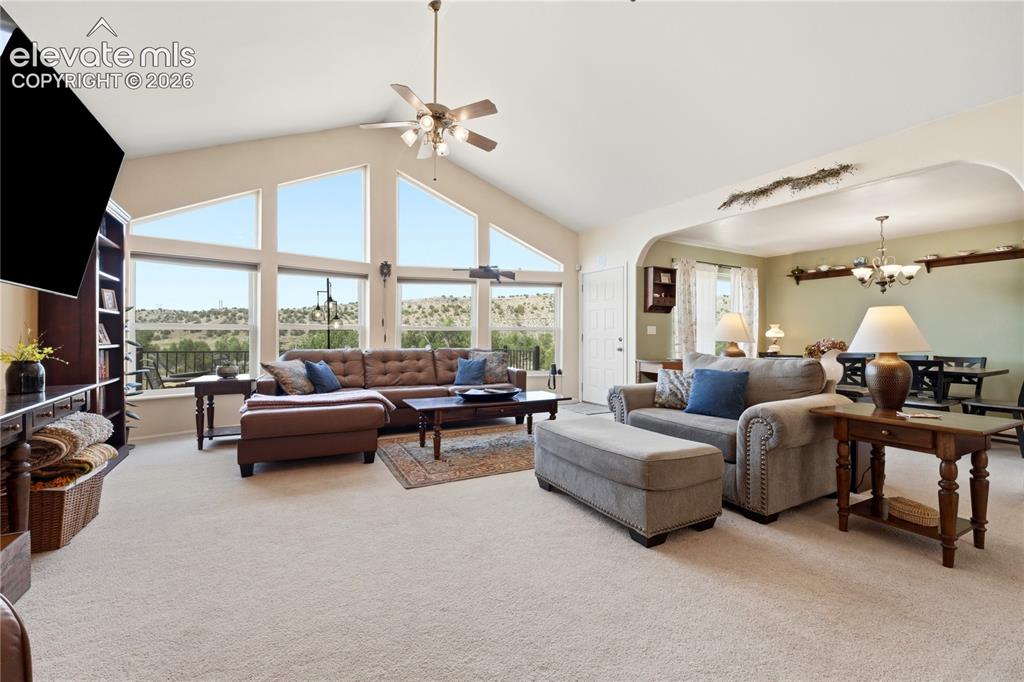 Image 24 of 49: Vaulted ceiling with a ceiling fan, expansive windows, built-in shelving, a
