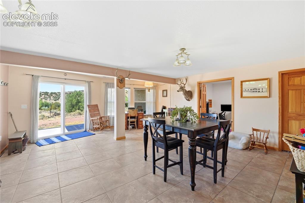 Image 41 of 49: Tile flooring, recessed lighting, sliding glass door, and a built-in wood d