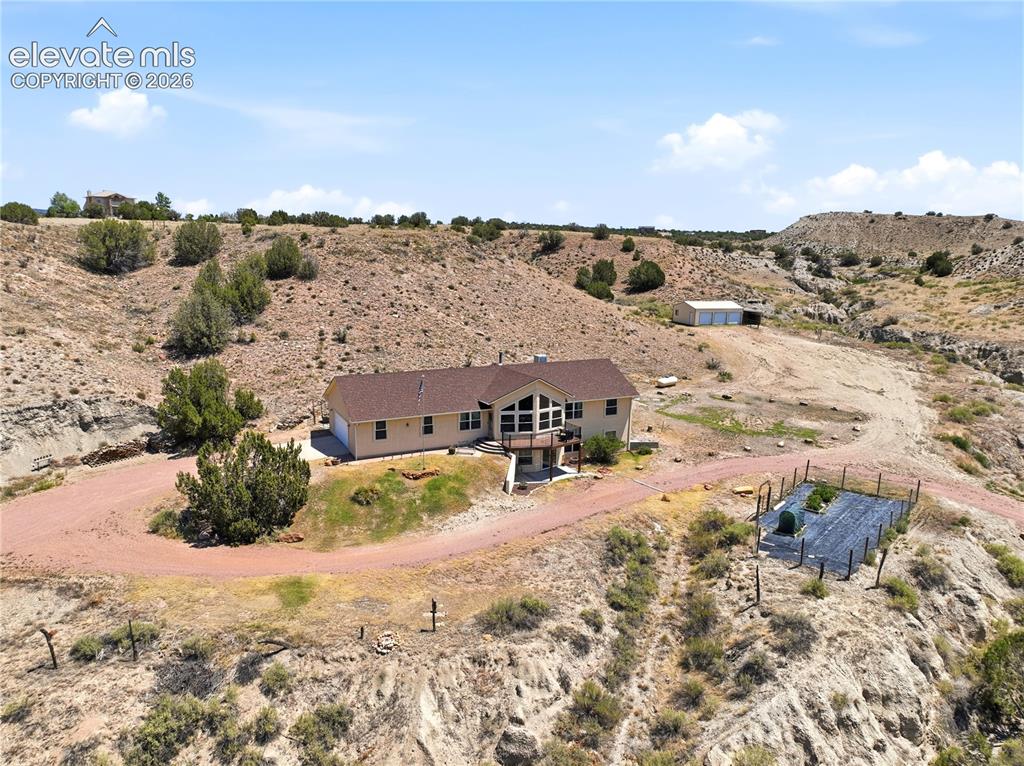 Image 5 of 49: Ranch-style residence featuring a detached two-car garage, expansive deck,