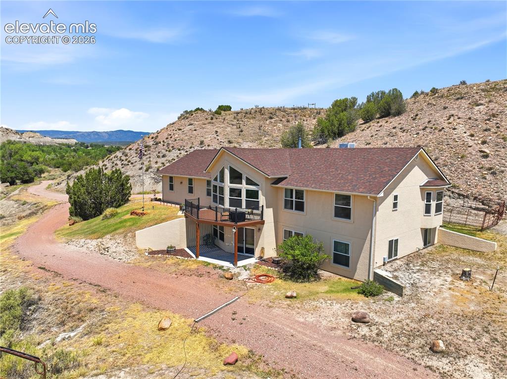 Image 6 of 49: Multi-level residence featuring a prominent balcony, bay window, and expans