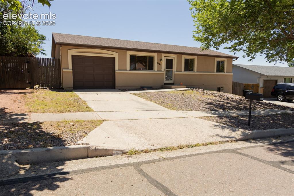 Image 3 of 38: Ranch-style exterior featuring a brown garage door, concrete driveway, and 
