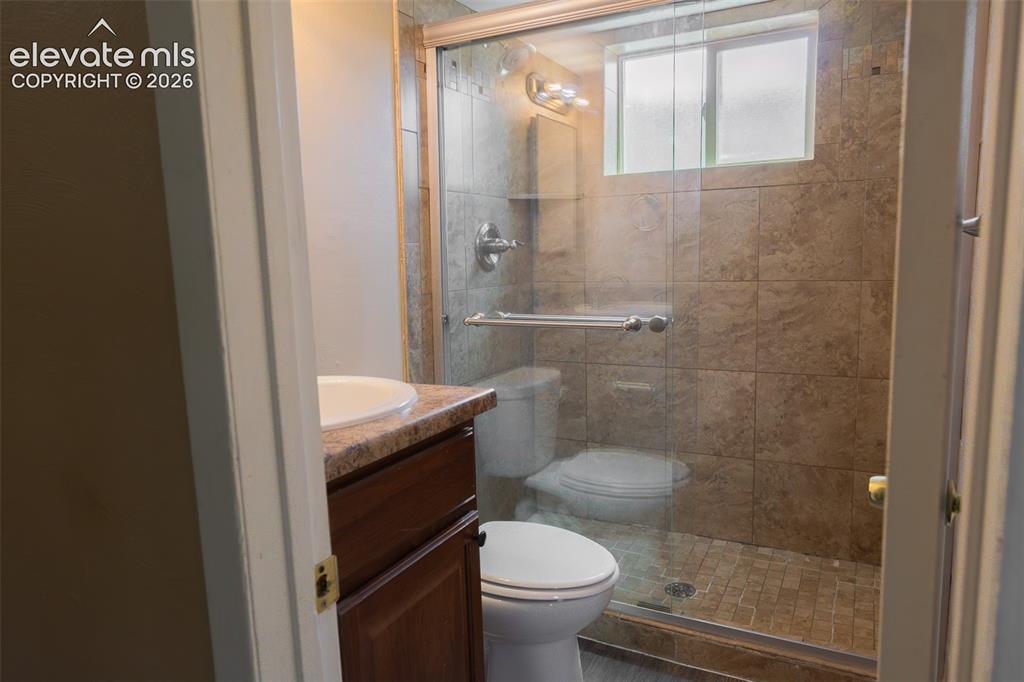 Image 35 of 38: Bathroom featuring a glass-enclosed shower with tile surround, a built-in w