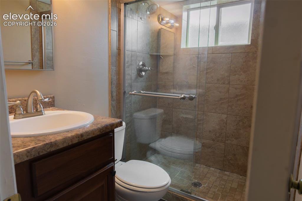 Image 36 of 38: Glass-enclosed shower with tiled walls and flooring