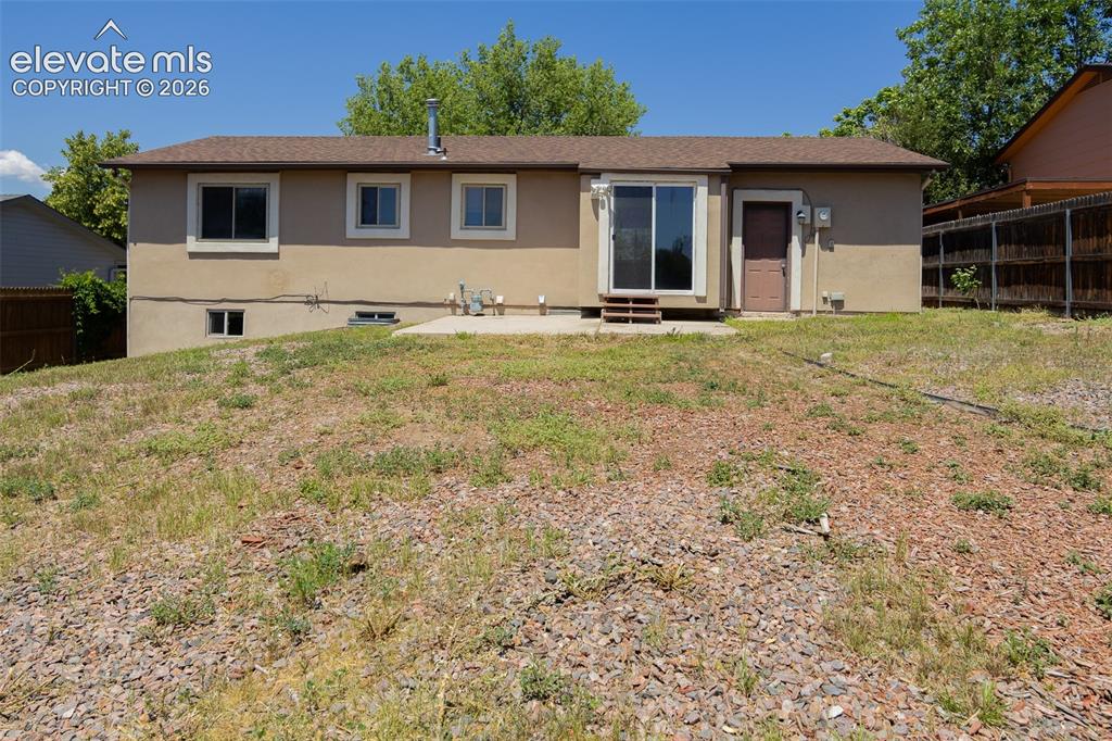 Image 4 of 38: Rear exterior featuring a sliding glass patio door, a secondary exterior do