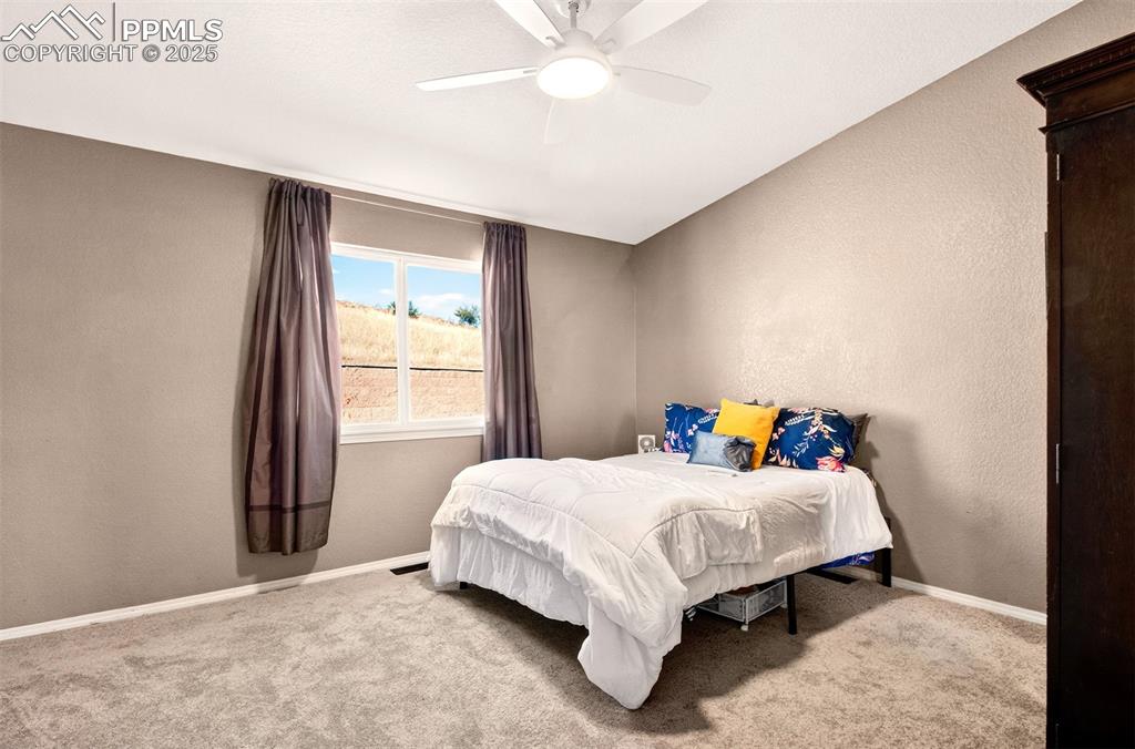 Image 10 of 21: Primary bedroom with a textured wall and ceiling fan