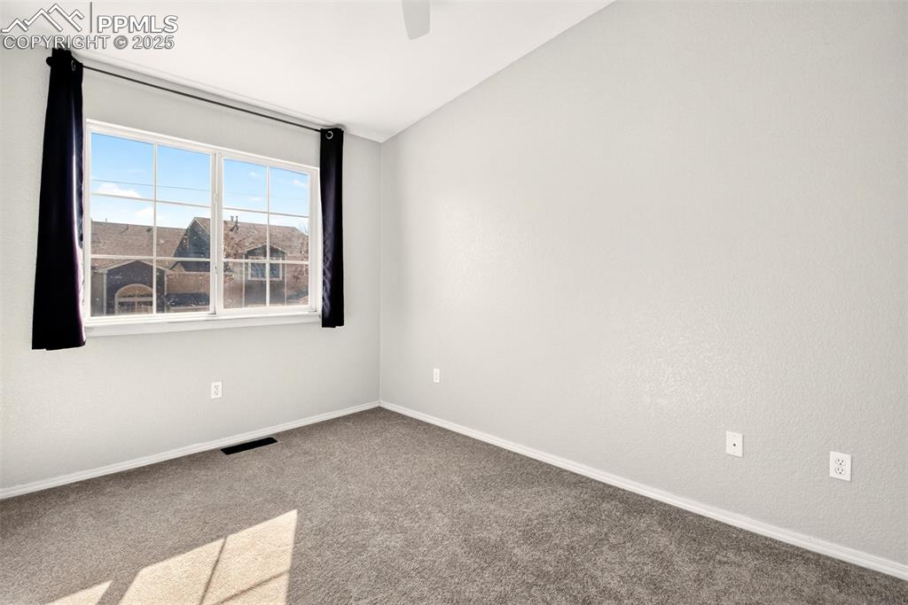 Image 12 of 21: Carpeted spare room with lofted ceiling and a ceiling fan