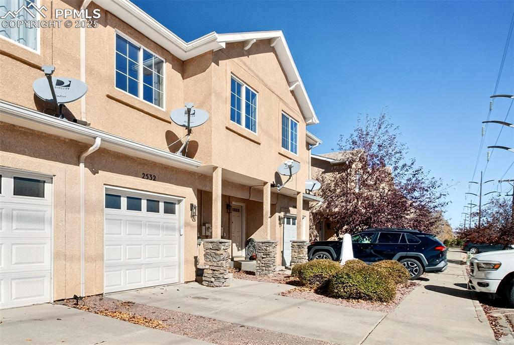 Image 2 of 21: View of fronton home with stucco siding, concrete driveway, and stone sidin