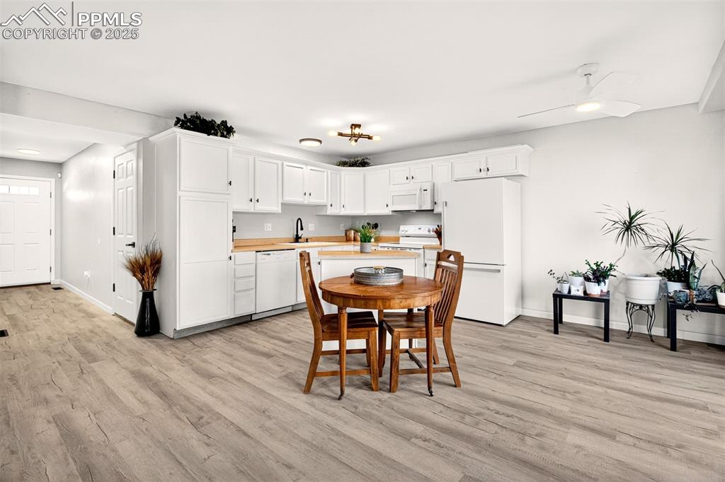 Image 4 of 21: Dining space with light wood finished floors and ceiling fan