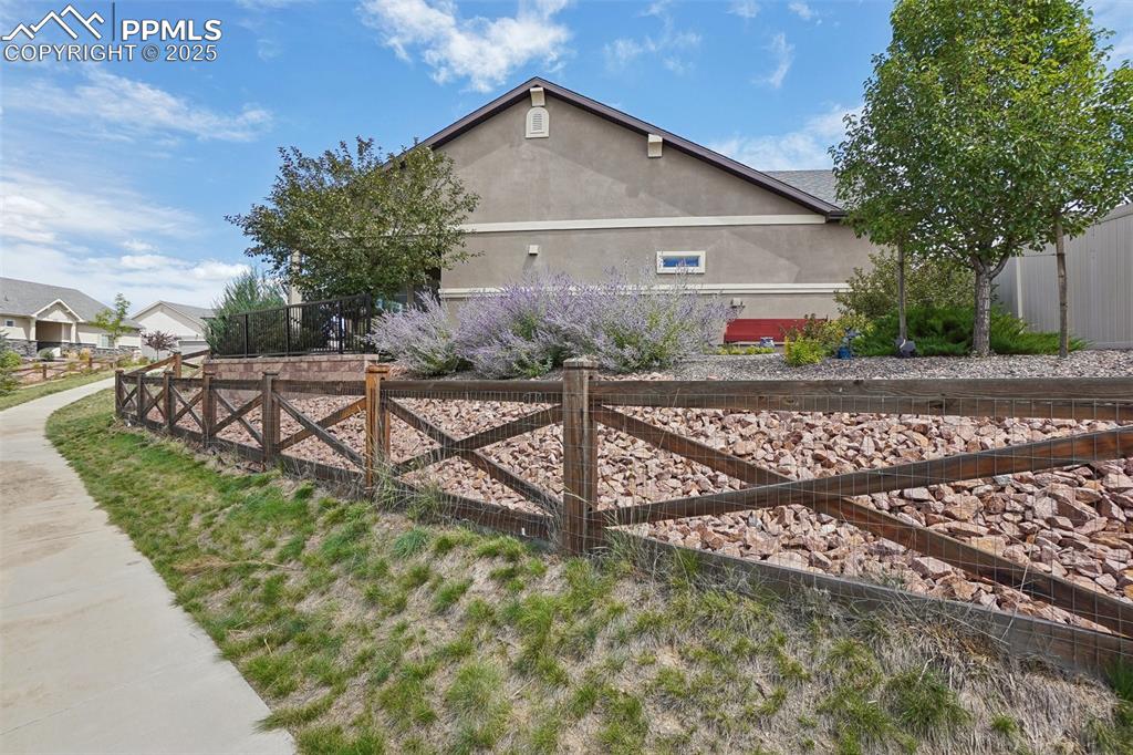 Image 43 of 48: View of side of home featuring stucco siding and fence